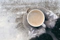 Winter picture: hands in knitted gray gloves holding a Cup of hot coffee on a snowy day on a wooden rustic background in the