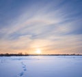 Winter plain covered by a snow at the sunset with human track