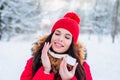 Winter portrait of a beautiful woman with facial cream and snowflake on winter background. Face skin care in winter Royalty Free Stock Photo