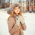 Winter portrait beautiful young woman wearing coat jacket and hat over snow Royalty Free Stock Photo