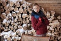 Winter portrait of blonde woman on firewood background