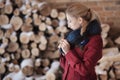 Winter portrait of blonde woman on firewood background