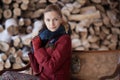 Winter portrait of blonde woman on firewood background