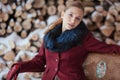 Winter portrait of blonde woman on firewood background