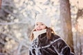 Winter portrait of cute smiling child girl in sunny snowy forest