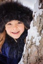 Winter portrait of cute smiling child girl on the walk in sunny snowy forest