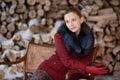 Winter portrait of the girl on a background firewood