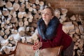 Winter portrait of the girl on a background firewood