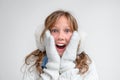 Winter portrait of a girl in a muffler and gloves surprised and delighted