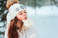 Winter portrait of happy child girl in white coat, hat and mittens playing outdoor in snowy winter forest Royalty Free Stock Photo