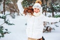 Winter portrait of happy child girl in white coat, hat and mittens playing outdoor in snowy winter forest Royalty Free Stock Photo