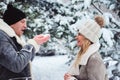 winter portrait of happy couple playing, blowing snow and spending good day outdoor in snowy forest. Royalty Free Stock Photo