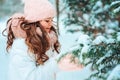 Winter portrait of happy kid girl in white coat and hat and pink mittens playing outdoor in snowy winter forest Royalty Free Stock Photo