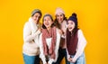 Winter portrait of happy latin family three generations of hispanic women on yellow background in Mexico Latin America Royalty Free Stock Photo