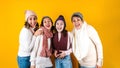 Winter portrait of happy latin family three generations of hispanic women on yellow background in Mexico Latin America Royalty Free Stock Photo