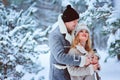 winter portrait of happy romantic couple enjoying their walk in snowy forest or park Royalty Free Stock Photo