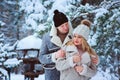 Winter portrait of happy romantic couple enjoying their walk in snowy forest or park Royalty Free Stock Photo