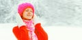 Winter portrait of happy smiling cute young woman wearing knitted hat, sweater and scarf enjoys outdoors on snowy park background Royalty Free Stock Photo