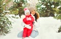 Winter portrait of happy smiling mother and little girl child outdoors on christmas tree background with snowflakes Royalty Free Stock Photo