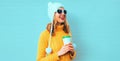 Winter portrait happy smiling young woman with coffee cup looking away wearing yellow knitted sweater, white hat with pom pom Royalty Free Stock Photo