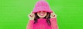 Winter portrait of happy smiling young woman wearing pink knitted sweater, hat having fun on green background Royalty Free Stock Photo