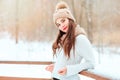 winter portrait of happy young woman walking outdoor in snowy park