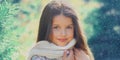 Winter portrait little girl child wearing a knitted scarf near christmas tree Royalty Free Stock Photo