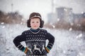 Winter portrait of little kid boy wearing a knitted sweater with deers, outdoors during snowfall. Royalty Free Stock Photo