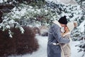 winter portrait of romantic couple kissing in snowy forest.