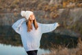 Winter portrait of smilling woman in white hat with big bubo makes funny face