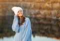 Winter portrait of smilling woman in white hat with big bubo makes funny face