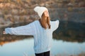 Winter portrait of smilling woman in white hat with big bubo makes funny face