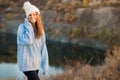 Winter portrait of smilling woman in white hat with big bubo makes funny face