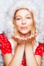 Winter portrait of woman blowing snow flakes