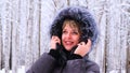 Winter portrait of a young beautiful brunette woman in a winter jacket with fur. Snow winter beauty concept Royalty Free Stock Photo