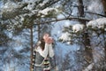 Winter portrait. Young, beautiful woman blowing snow toward camera on winter background Royalty Free Stock Photo