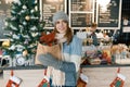 Winter portrait of young beautiful woman in knitted scarf, knitted hat, mittens, warm sweater with Christmas red poinsettia flower Royalty Free Stock Photo