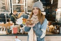 Winter portrait of young beautiful woman in knitted scarf, knitted hat, mittens, warm sweater with bowl of hazelnuts and walnuts Royalty Free Stock Photo