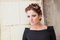 Winter portrait of young brunette on the background of a wall of an abandoned hospital