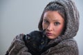 Winter portrait of young kind woman holding big black cat