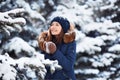 Winter portrait: Young pretty girl dressed in a warm woolen clothes, scarf and covered head posing outside. Royalty Free Stock Photo