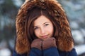 Winter portrait: Young pretty girl dressed in a warm woolen clothes, scarf and covered head posing outside. Royalty Free Stock Photo