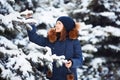 Winter portrait: Young pretty girl dressed in a warm woolen clothes, scarf and covered head posing outside. Royalty Free Stock Photo