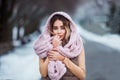 Winter portrait: Young pretty woman dressed in a warm woolen clothes, scarf and covered head posing outside. Royalty Free Stock Photo