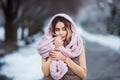 Winter portrait: Young pretty woman dressed in a warm woolen clothes, scarf and covered head posing outside. Royalty Free Stock Photo