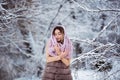 Winter portrait: Young pretty woman dressed in a warm woolen clothes, scarf and covered head posing outside. Royalty Free Stock Photo