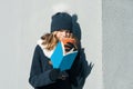 Winter portrait of young teen girl student in hat, warm clothes with cup of hot drink and book Royalty Free Stock Photo