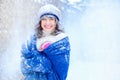 Winter portrait of a young woman. Beauty Joyous Model Girl touching her face skin and laughing, having fun in the winter park. Bea