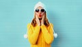 Winter portrait young woman blowing red lips sending sweet air kiss wearing yellow knitted sweater and white hat with pom pom Royalty Free Stock Photo