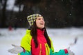 Winter portrait of the young woman in bright ski suit and a knitted cap.